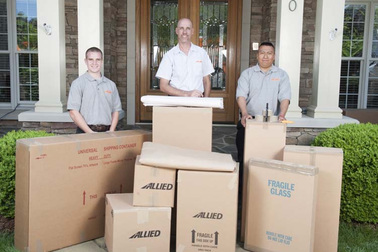 Reliable/Allied Team members posing behind moving boxes